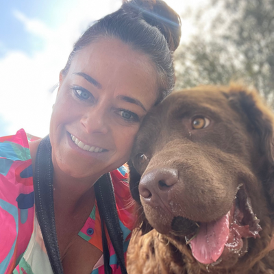 happy Woman with a happy brown dog outdoors on a sunny day
