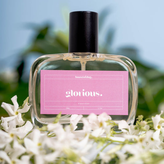 dog Perfume bottle labeled 'glorious.' with a pink label on a floral background