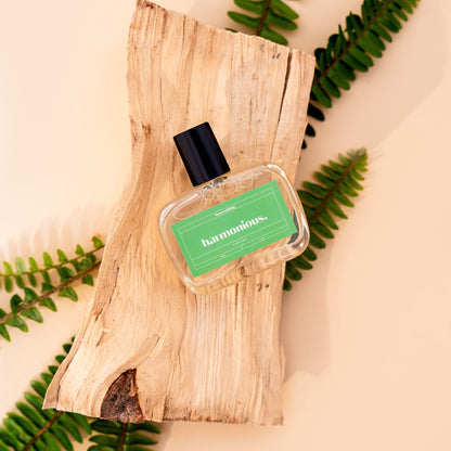 vegan dog fragrance labeled 'harmonious' on a wooden block with green leaves in the background